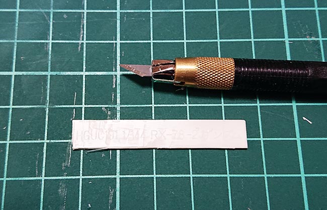 ランナータグの文字をデザインナイフで削ぎ取る