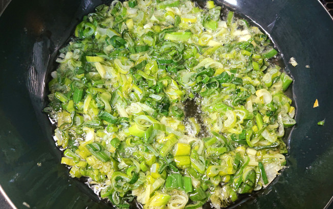 長ネギを油で揚げていく